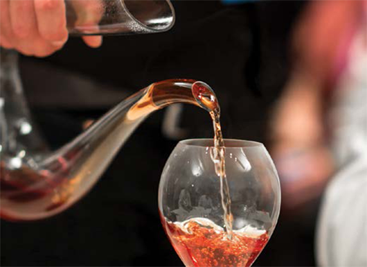 Wine Glass is being Poured with Tea Pouring Tea Into a Wine Glass from a Teapot