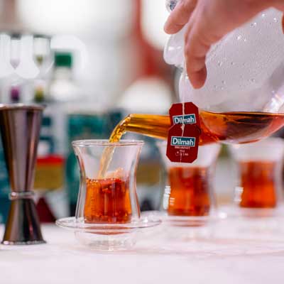 Pouring Tea Into Glass Cups from a Teapot