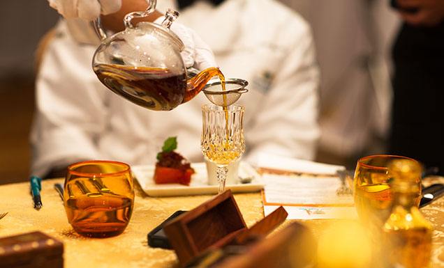 Pouring Tea Into a Glass Cup from A See through Teapot